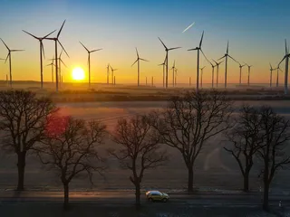 Aurinko nousi 7. helmikuuta 2023 Brandenburgissa Saksassa Jacobsdorf-nimisessä kylässä. Brandenburg lukeutuu osavaltioihin, joihin on rakennettu eniten tuulivoimaloita Saksassa. Alue saa kolmanneksen sähkönkulutuksestaan tuulivoimasta.