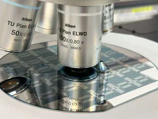 Kuvassa on VTT:n sähköisiä jäähdyttimiä piikiekolla, jota tutkitaan optisella mikroskoopilla.