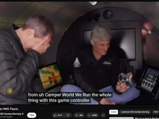 CBS:n toimittaja David Pogue hautasi kasvonsa käsiinsä nähdessään sukellusveneen ohjaimen. Kuvakaappaus CBS:n uutisvideolta.