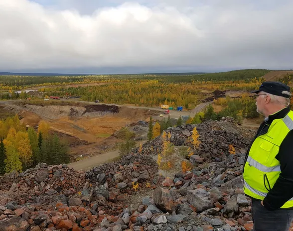 Päägeologi Jouko Pakarinen Hannukaisen kaivoshankkeen alueella syyskuussa 2017, jolloin alueella kairattiin ja louhittiin. Kivikasat ovat edellisen kaivoksen ajoilta.