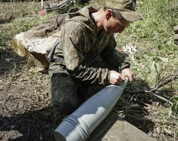 Venäjämielisen Donetskin kansantasavallan sotilas käsittelee tykistöammusta Avdiivkassa Donetskin alueella kesäkuussa 2022.