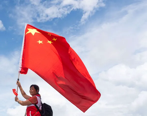 Konsulttiyritys Ipsosin selvityksen mukaan 91 prosenttia kiinalaisista kokee olevansa onnellisia. Kuvassa nainen juhlistamassa Hongkongin palautuksen 26-vuotismerkkipäivää Kiinalle heinäkuun alussa.
