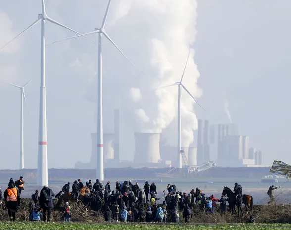 Garzweilerin avolouhosta laajennetaan, ja sen tieltä puretaan tuulivoimaloita. Taustalla hiilivoimaloita, etualalla ympäristöaktivistien mielenosoitus tammikuussa 2023.