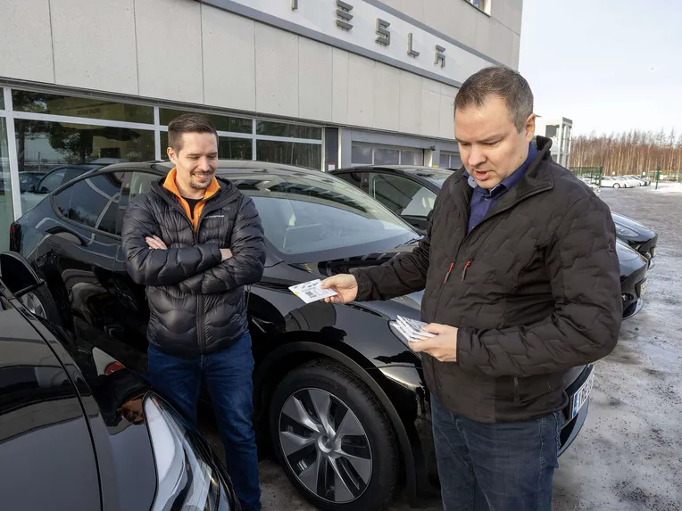 T Taxin toinen pääosakas Toni Kähkönen (oik) tutki uusien autojen avainkortteja Harri Pusan (vas) kanssa. Teslan avaimena toimii kortin lisäksi kännykkä ja avaimen voi jakaa muille Whatsapp-viestillä. Puhelimesta kuski näkee auton tarkan sijainnin, mikä helpottaa vuoronvaihtoja.