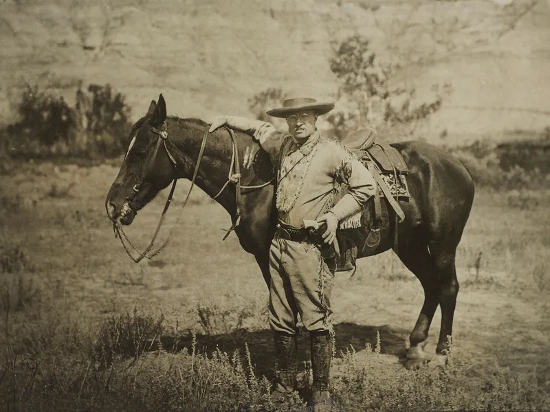 Theodore Roosevelt seisoo hevosen vieressä.