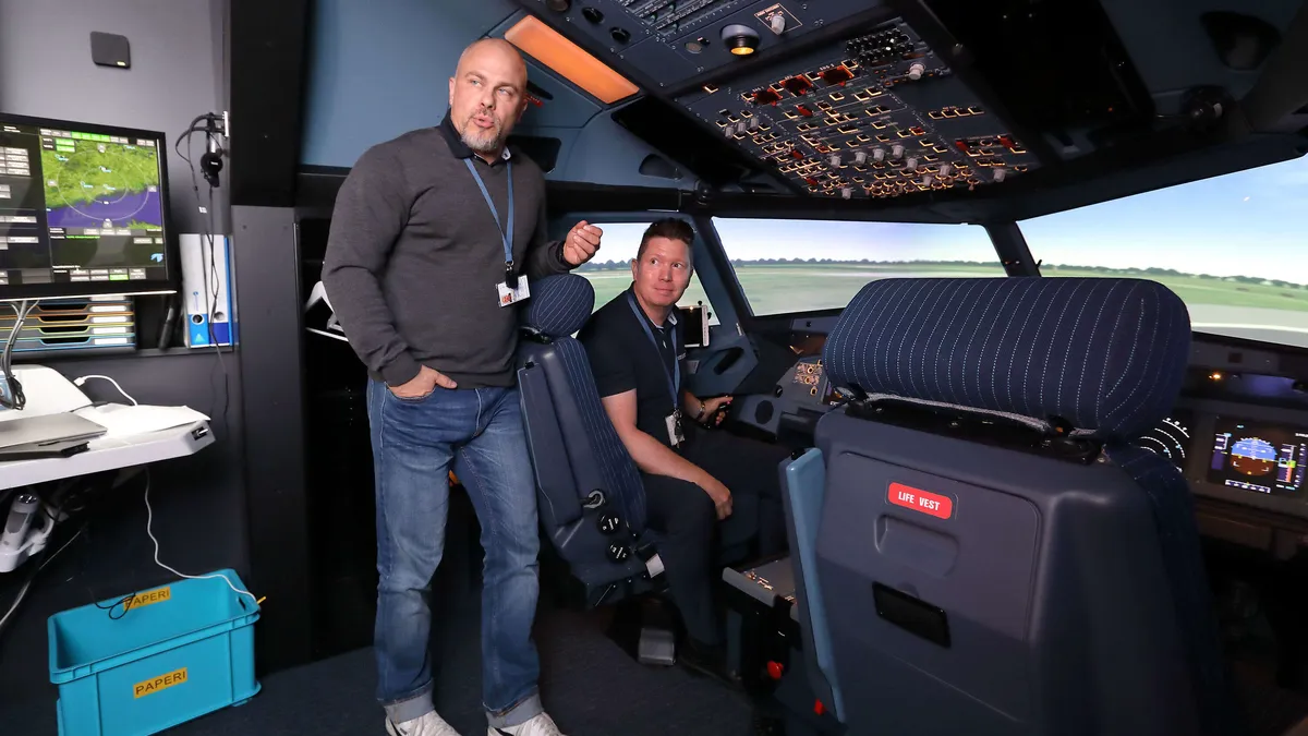 Suomen Ilmailuopiston opettajat Janne Pöykiö (vas.) ja Sauli Kuortti opiston uudessa Airbus A320-lentosimulaattorissa. Simulaattorit ovat yksi Suomen Ilmailuopiston vetonauloista.