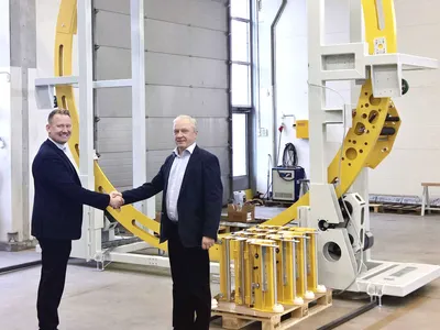 Octomecan toimitusjohtaja Janne Koskela (vasemmalla) ja Fromm Pakkauksen toimitusjohtaja Magnus Engblom maailman suurimman
                              täysautomaattisen kiristekäärintäkoneen äärellä.