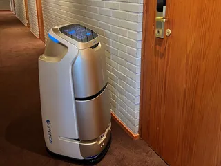 Hotellin työntekijä valitsee robotin  näytöltä, mihin huoneeseen toimitus tehdään.