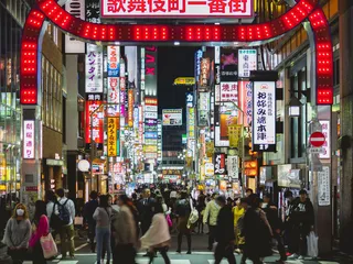 Street scene of Tokyo in the night. Many peoples and neon signs. Pedestrian crosswalk.