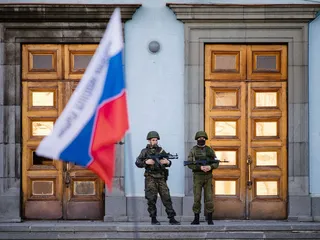 Sotilaat vartioivat hallintorakennusta Simferopolissa Krimillä maaliskuun alussa 2014. Venäjä valtasi Krimin
                              käyttäen muun muassa tunnuksettomia sotilaita ja moottoripyöräjengiläisiä. Hybridiuhkiin keskittyvää keskusta ei olisi, ellei
                              Venäjä