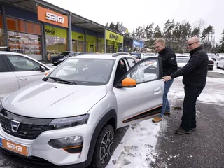 Yksi edullisimmista sähköautoista on Dacia  Spring, jota tuodaan Suomeen vain käytettynä. Samuli Saarikettu (vasemmalla) lähti koeajolle ja Raision Saka-autokaupan myyjä Tomi Seppälä opasti.