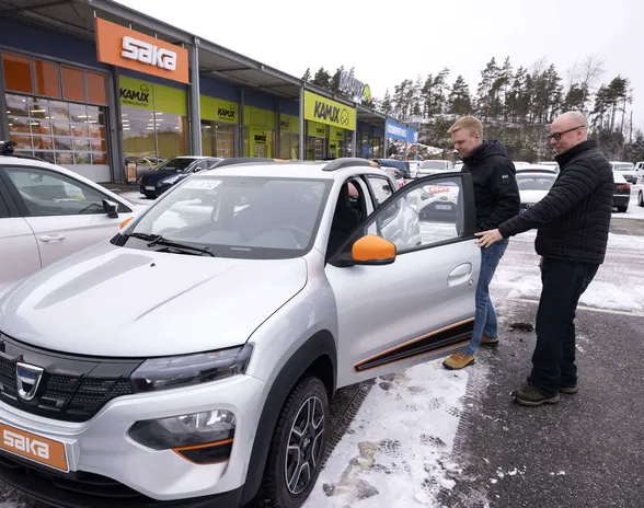 Yksi edullisimmista sähköautoista on Dacia  Spring, jota tuodaan Suomeen vain käytettynä. Samuli Saarikettu (vasemmalla) lähti koeajolle ja Raision Saka-autokaupan myyjä Tomi Seppälä opasti.