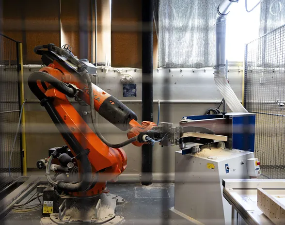 Hiontarobotti työskentelee erillään ihmisistä turva-aidan sisällä.