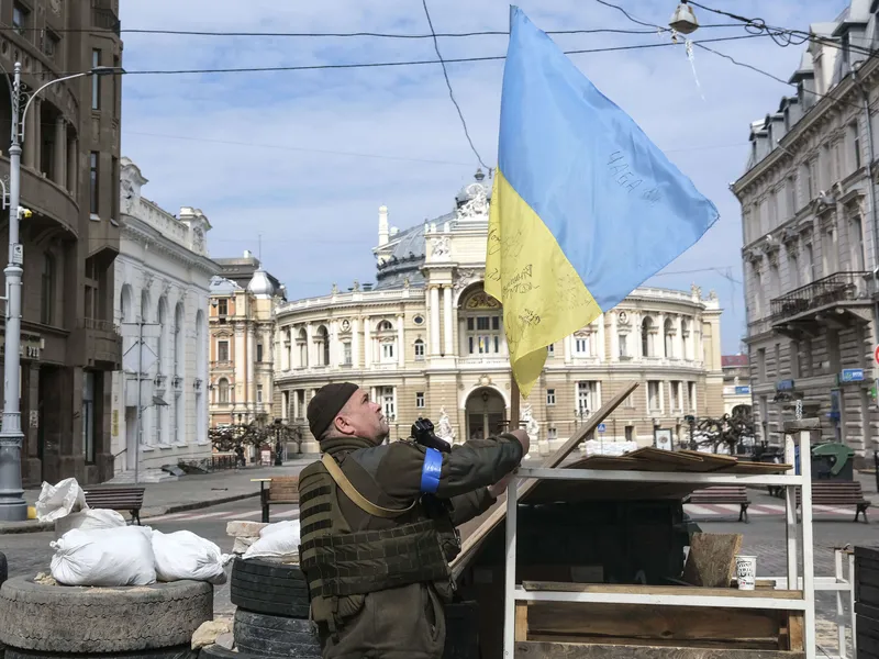 Sotilas nosti Ukrainan lippua katusululla Odessassa 21. maaliskuuta.