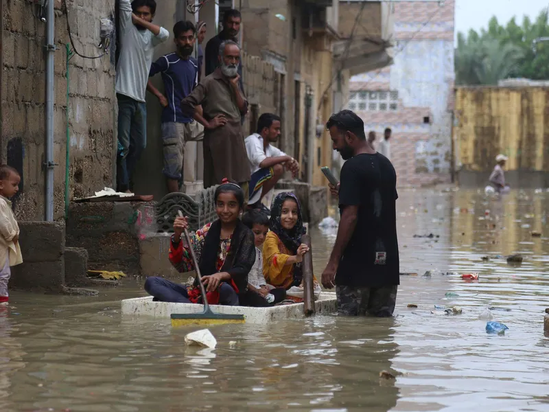 Pakistanin tulvat veivät kodin kahdeksalta miljoonalta ihmiseltä. Kuvan lapset liikkuivat kotitekoisella lautalla Karachissa viime heinäkuussa tulvan jälkeen.