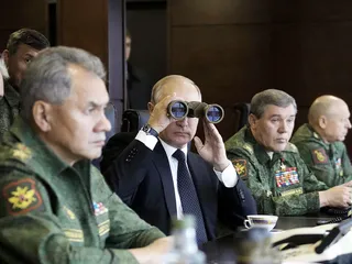 Presidentti Vladimir Putin (kiikaroi) rinnallaan uskotut kenraalinsa, puolustusministeri Sergei Shoigu (vas.)
                              ja yleisesikunnan päällikkö Valeri Gerasimov (toinen oik.)