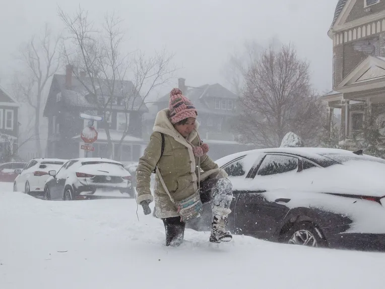 Jessica Chan tarpoo lumessa New Yorkin Buffalossa jouluaattona 2022.  Myrskyt aiheutti syklonipommi, joka muodostuu ilmanpaineen laskiessa hyvin nopeasti.