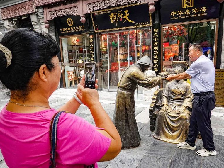 A tourist photographed a street artist in Beijing in August. Like Japan, China has a cultural heritage that dates back thousands of years.